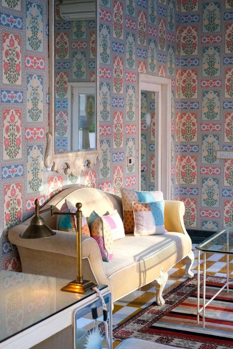 a living room with a couch and a mirror at Rajmahal Palace RAAS in Jaipur
