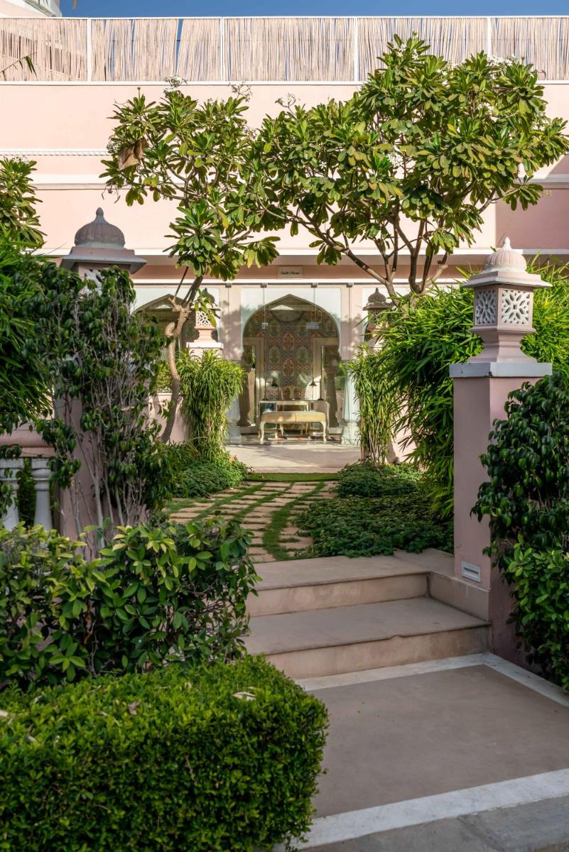 a garden with a staircase leading to a house at Rajmahal Palace RAAS in Jaipur