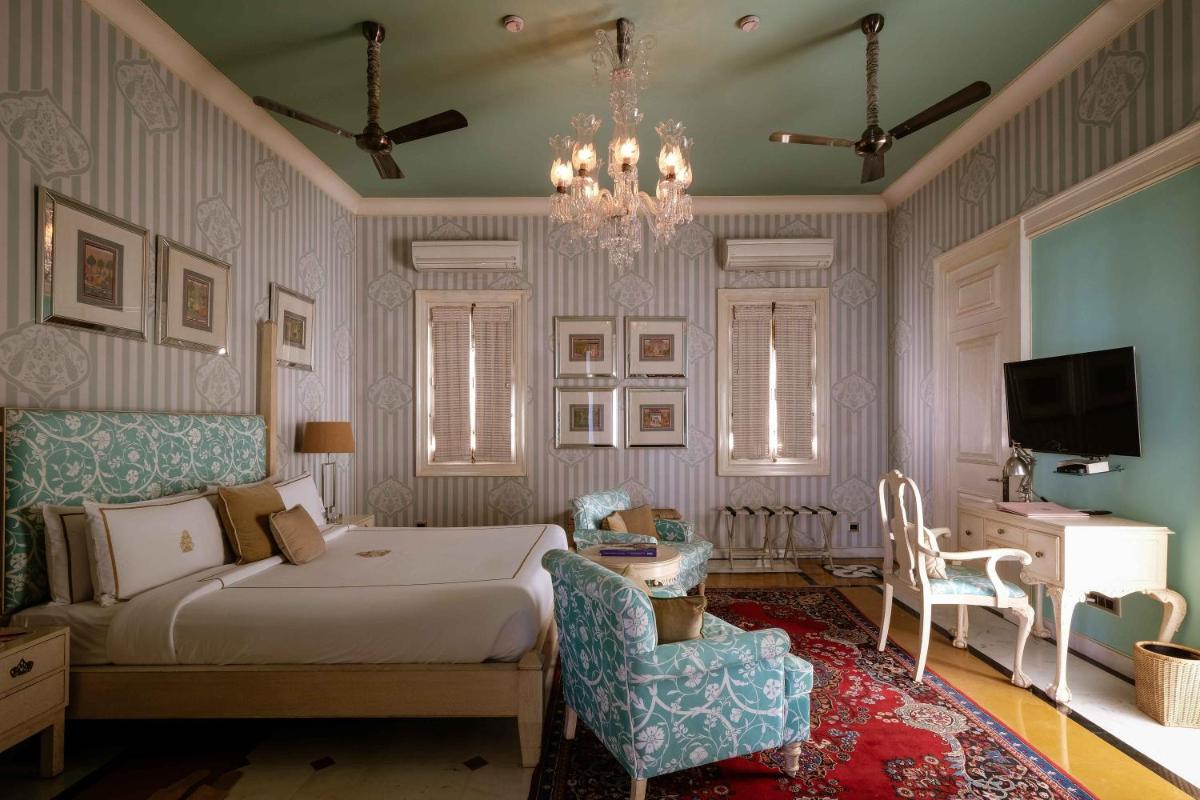 a bedroom with a bed and a chandelier at Rajmahal Palace RAAS in Jaipur