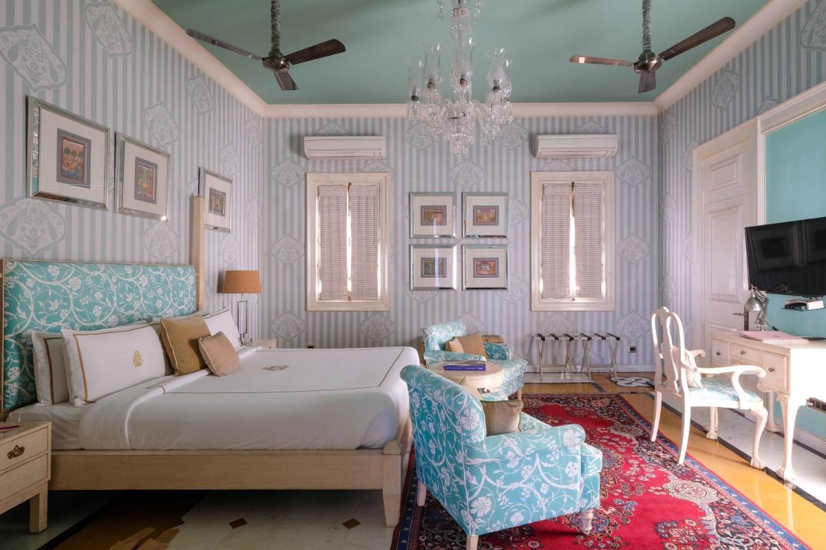 a bedroom with a bed and a chair and a tv at Rajmahal Palace RAAS in Jaipur