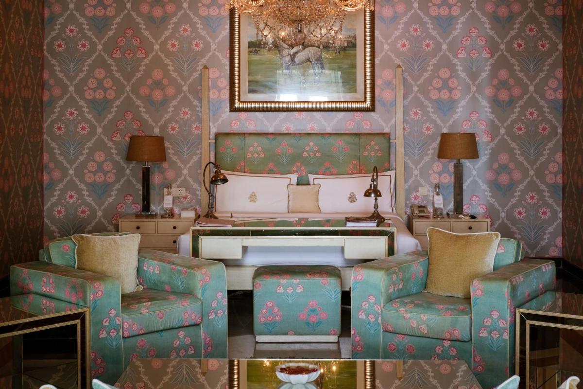 a living room with a piano and two chairs at Rajmahal Palace RAAS in Jaipur