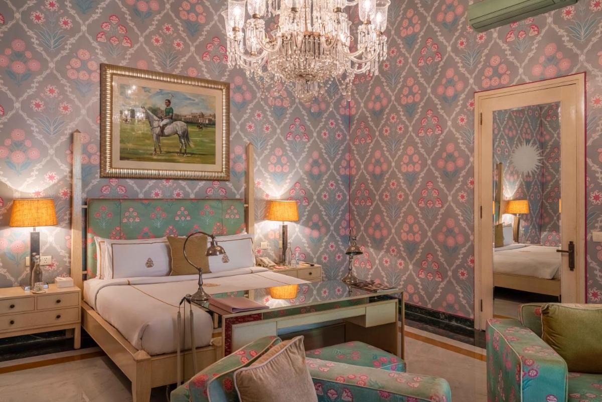 a bedroom with a bed and a chandelier at Rajmahal Palace RAAS in Jaipur