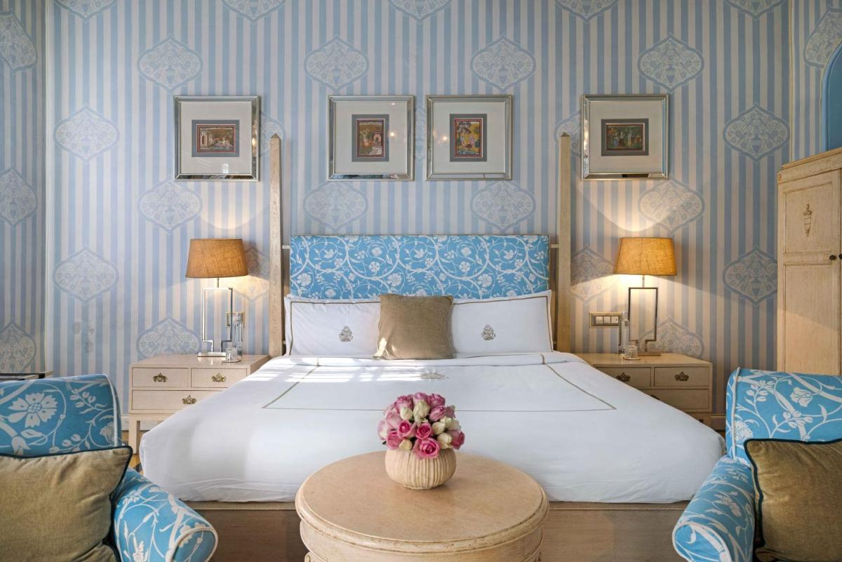 a bedroom with a large bed with blue and white stripes at Rajmahal Palace RAAS in Jaipur