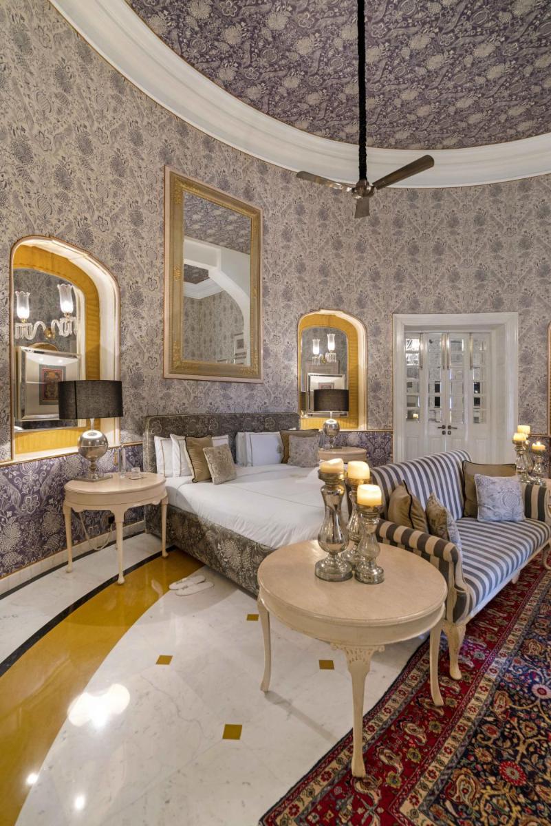a living room with a bed and a couch and tables at Rajmahal Palace RAAS in Jaipur