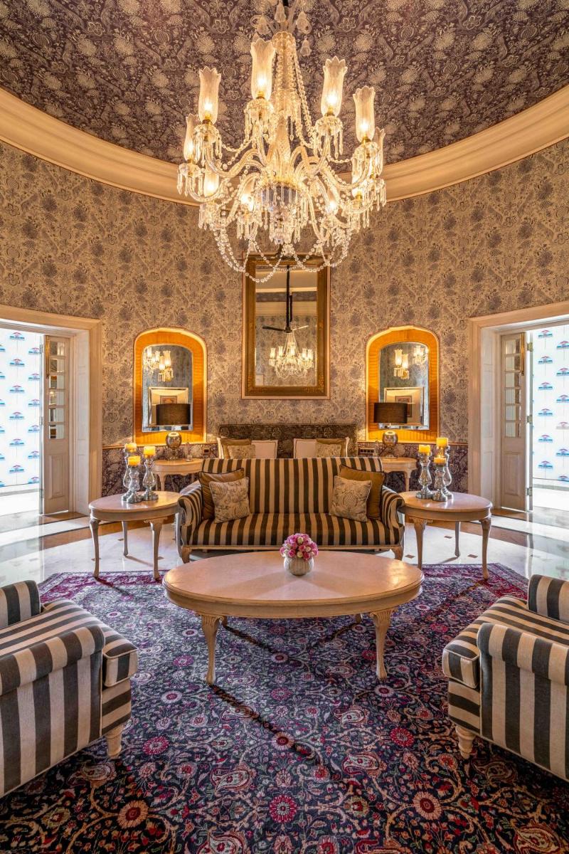 a living room with couches and a chandelier at Rajmahal Palace RAAS in Jaipur