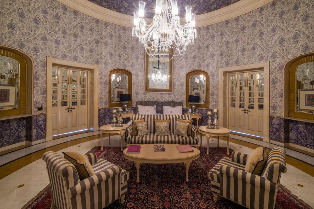 a living room with couches and a chandelier at Rajmahal Palace RAAS in Jaipur