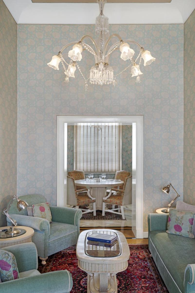 a living room with blue furniture and a chandelier at Rajmahal Palace RAAS in Jaipur