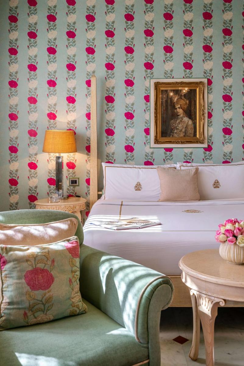 a bedroom with a bed and a couch and a table at Rajmahal Palace RAAS in Jaipur