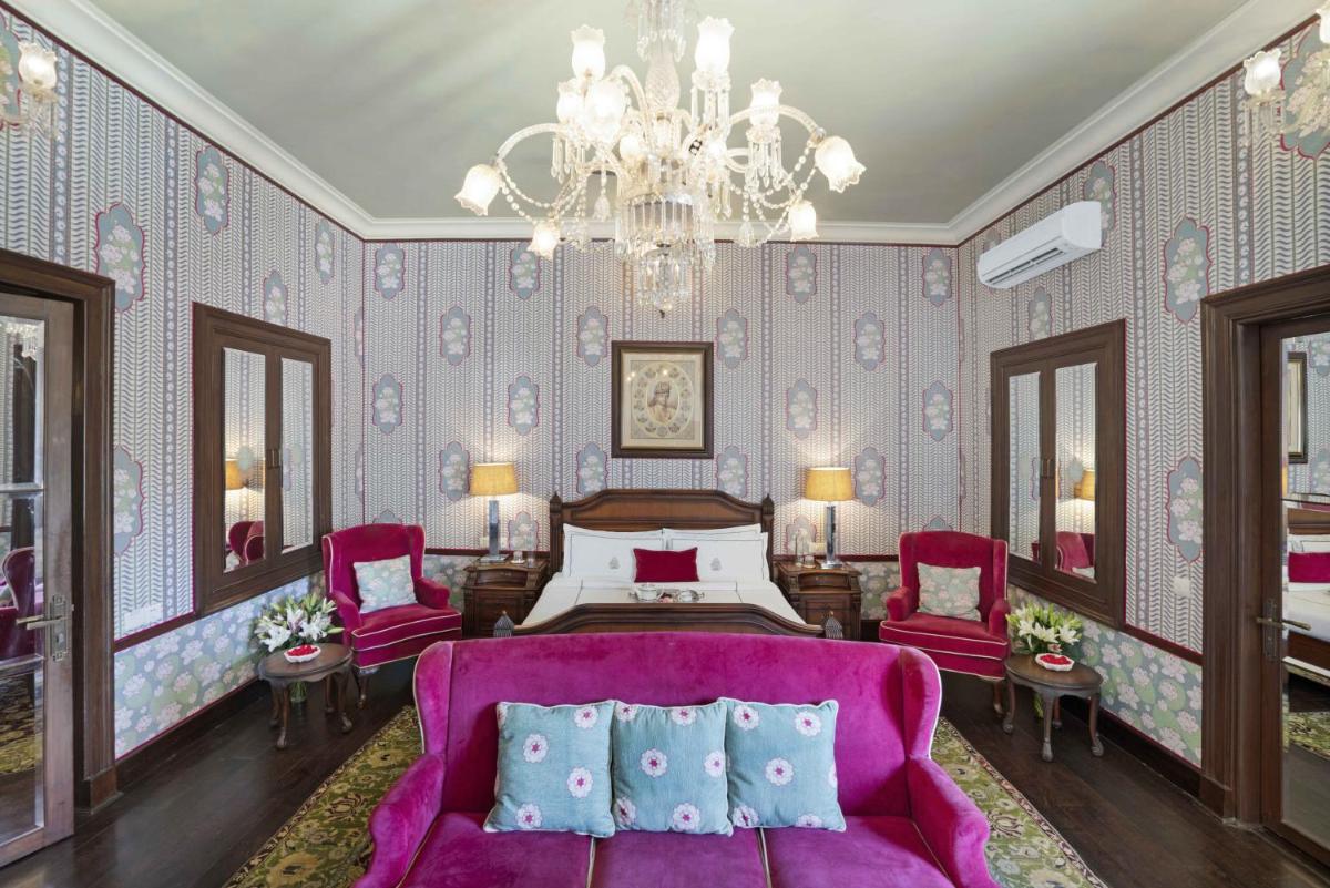 a bedroom with a purple bed and a chandelier at Rajmahal Palace RAAS in Jaipur +199 photos