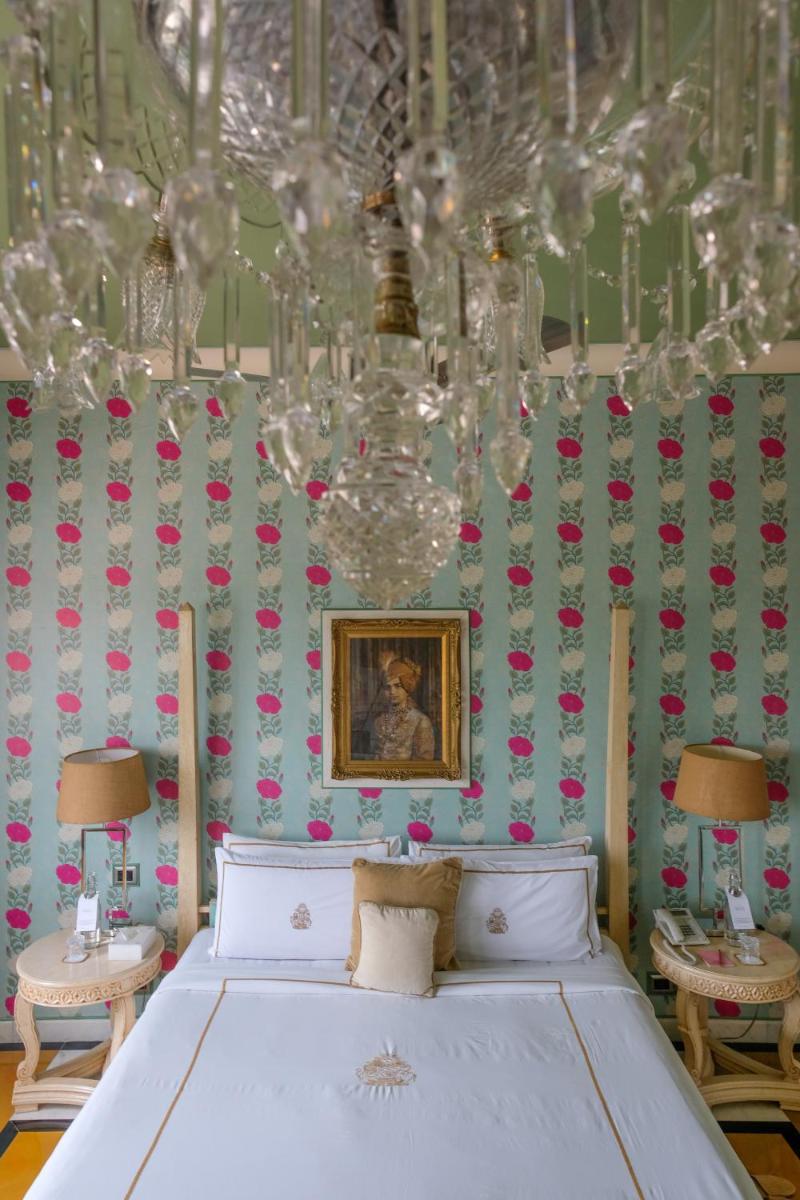 a bedroom with a bed and a chandelier at Rajmahal Palace RAAS in Jaipur
