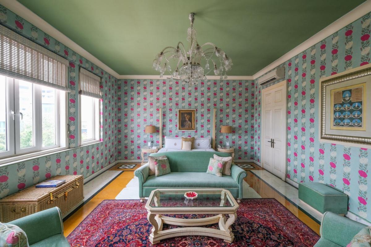 a living room with a couch and a chandelier at Rajmahal Palace RAAS in Jaipur