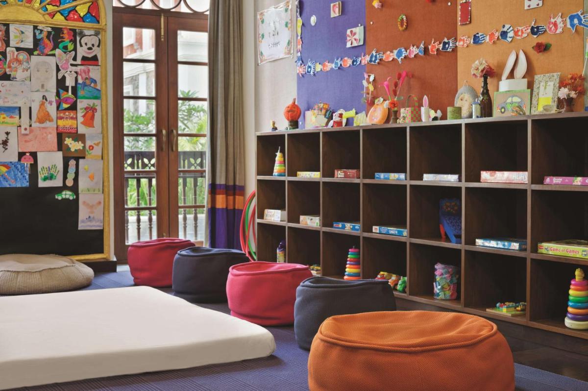 a childs room with a bed and chairs and shelves at Grand Hyatt Goa in Panaji a childs room with a bed and chairs and shelves at Grand Hyatt Goa in Panaji