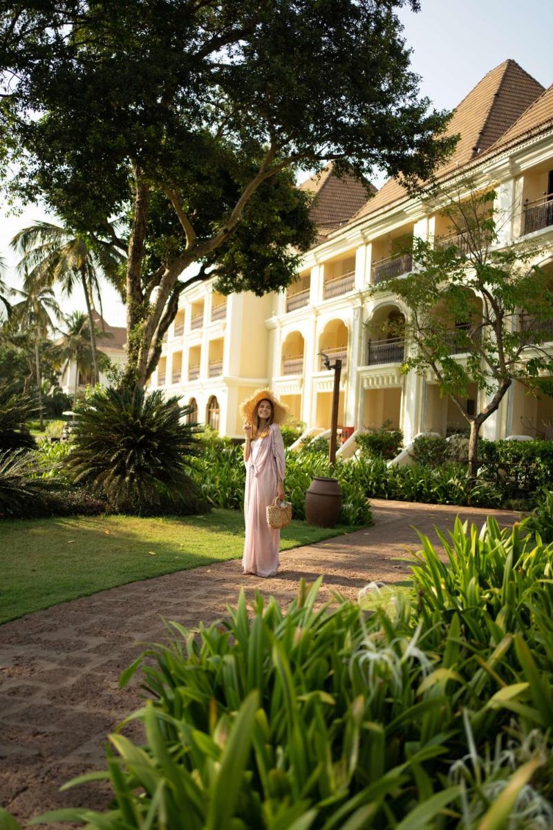 a woman standing in front of a large building at Grand Hyatt Goa in Panaji a woman standing in front of a large building at Grand Hyatt Goa in Panaji