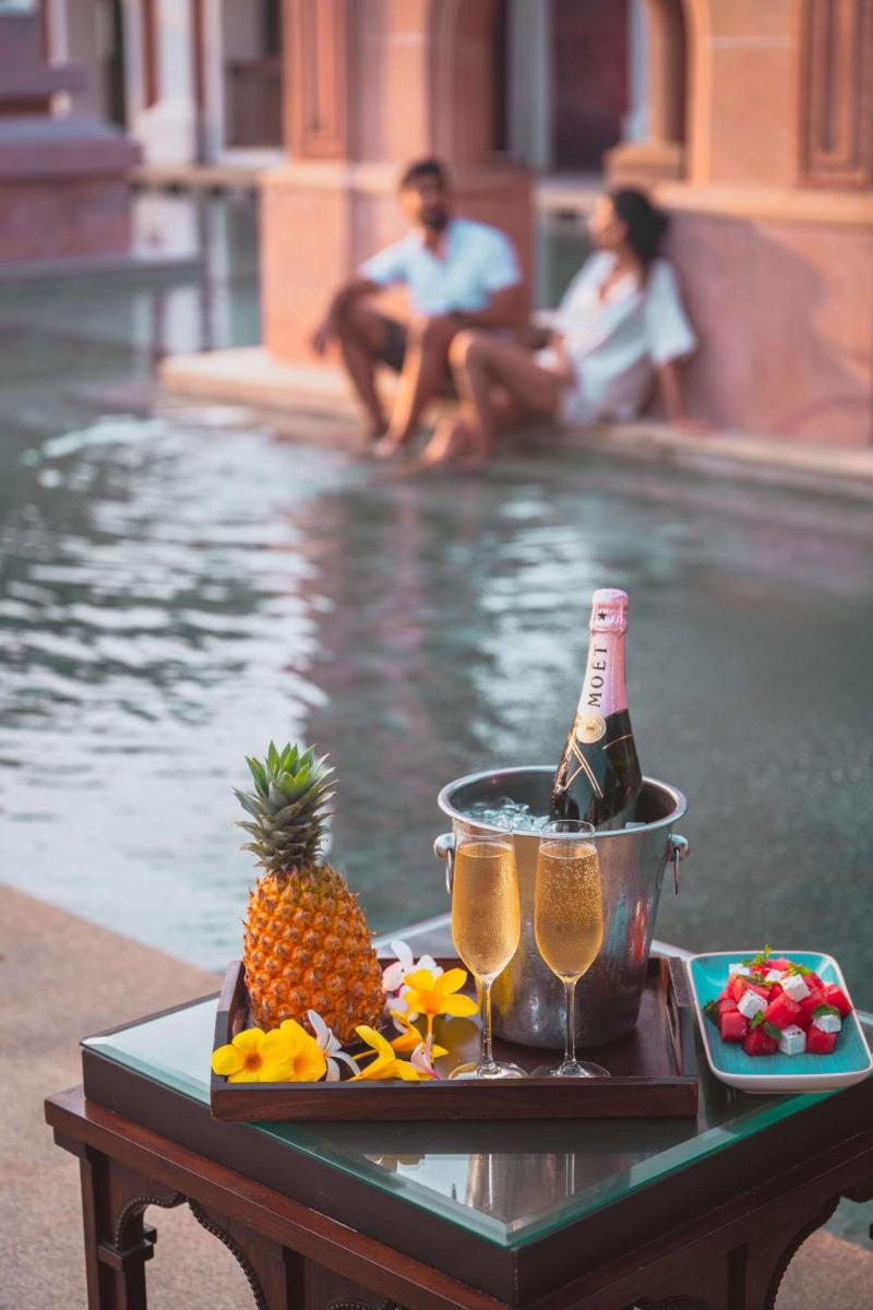a table with a bottle of champagne and a pineapple at Grand Hyatt Goa in Panaji a table with a bottle of champagne and a pineapple at Grand Hyatt Goa in Panaji