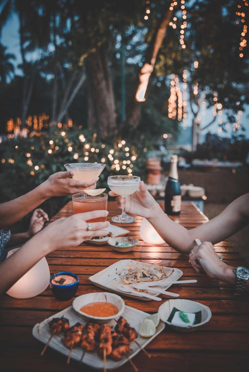 a group of people sitting around a wooden table with drinks at Grand Hyatt Goa in Panaji a group of people sitting around a wooden table with drinks at Grand Hyatt Goa in Panaji