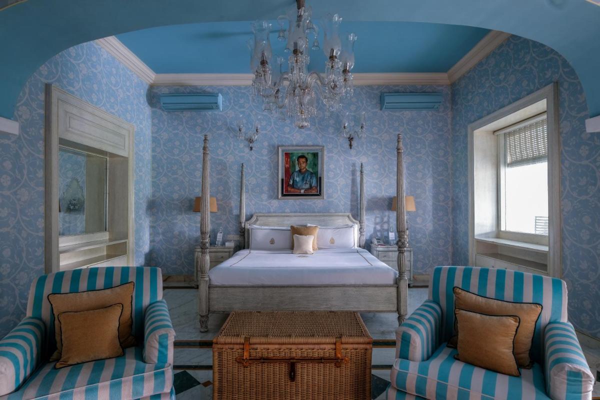 a bedroom with a bed and two chairs at Rajmahal Palace RAAS in Jaipur