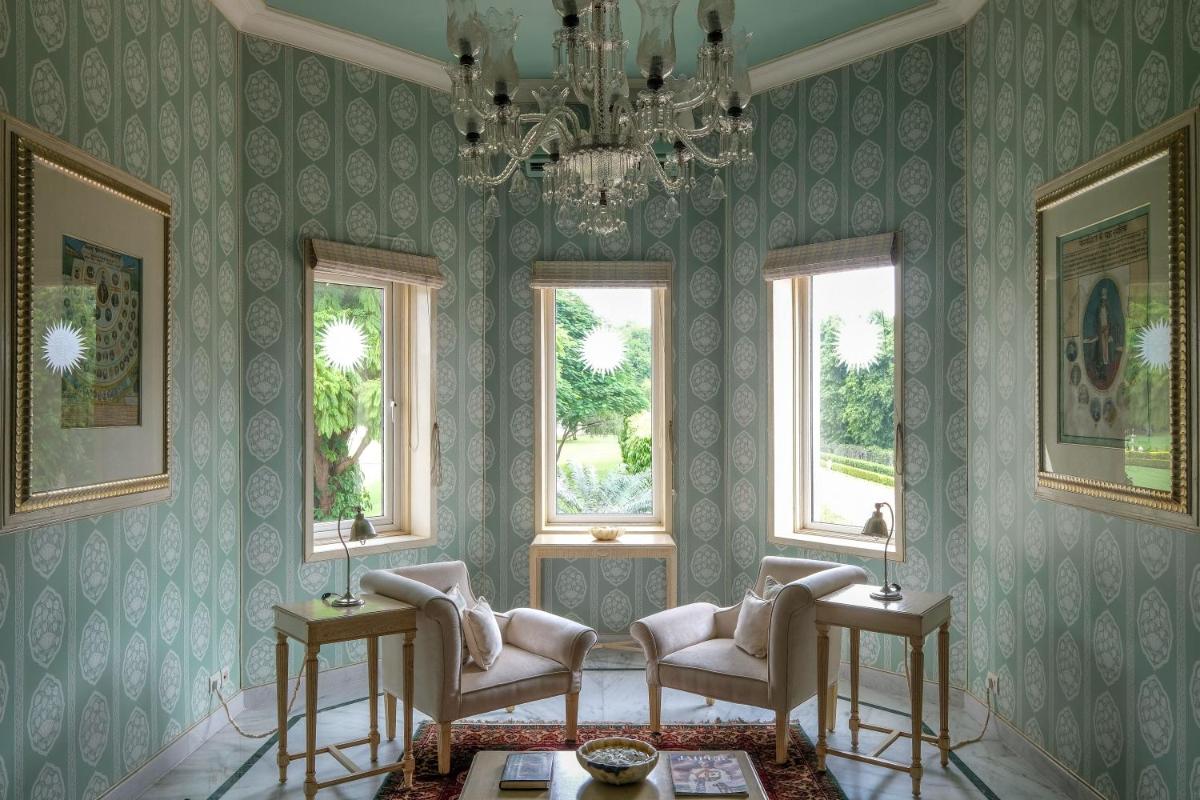 a living room with chairs and a chandelier at Rajmahal Palace RAAS in Jaipur