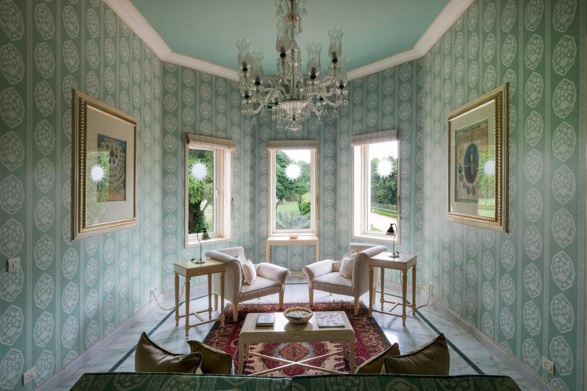 a living room with green wallpaper and a chandelier at Rajmahal Palace RAAS in Jaipur
