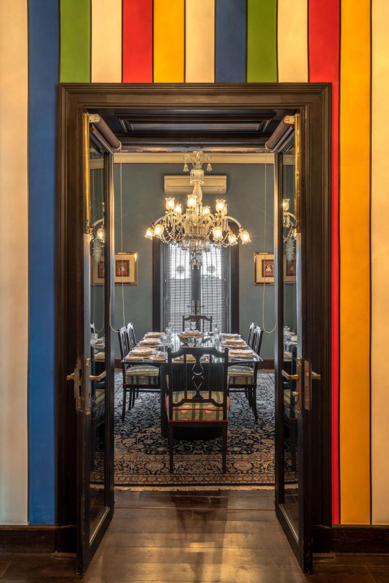 a dining room with a table and a colorful wall at Rajmahal Palace RAAS in Jaipur