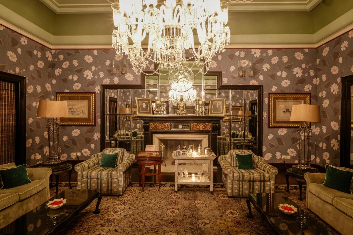 a living room with a chandelier and a fireplace at Rajmahal Palace RAAS in Jaipur