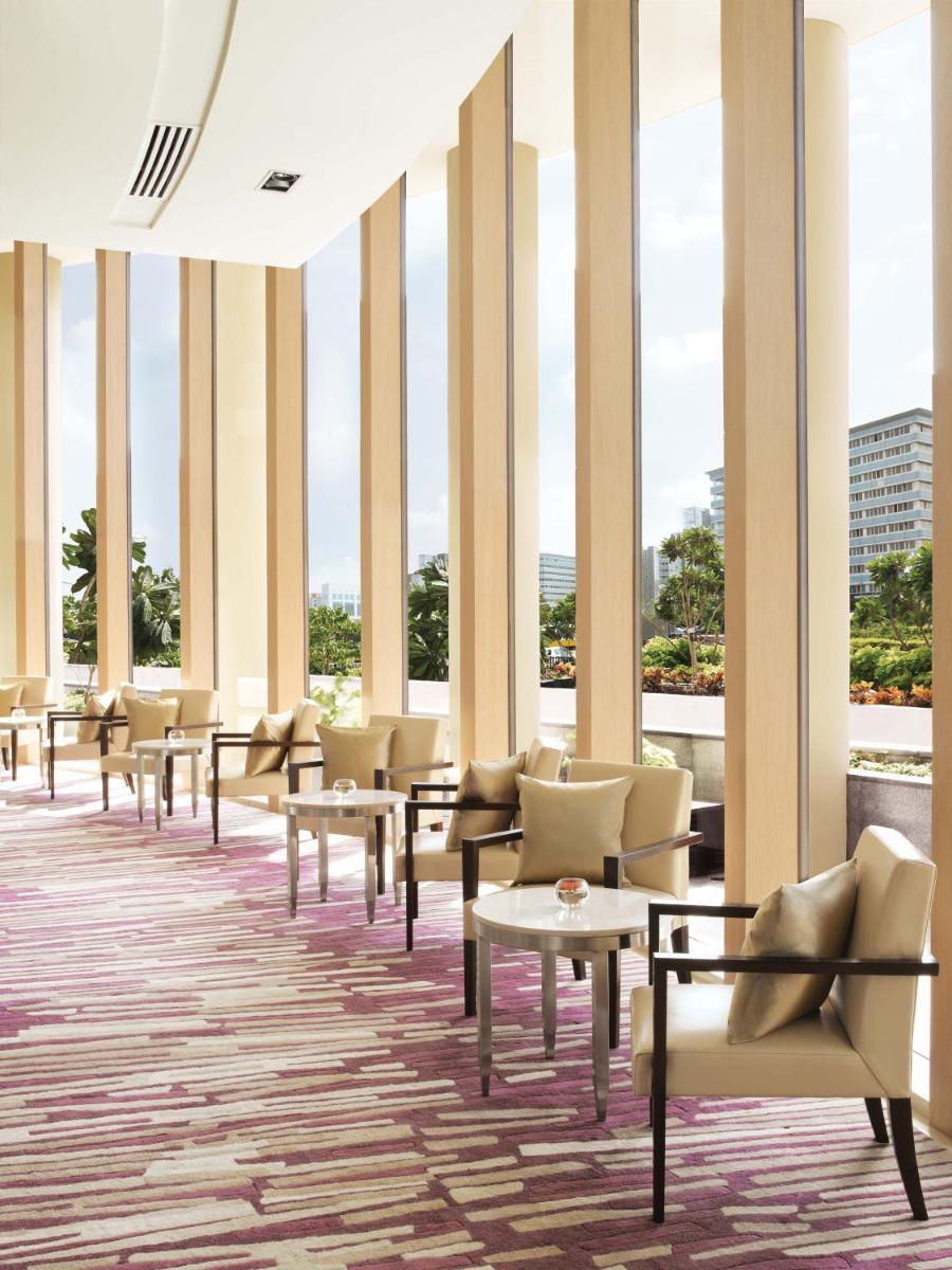 a row of chairs and tables in a room with windows at Trident Bandra Kurla in Mumbai a row of chairs and tables in a room with windows at Trident Bandra Kurla in Mumbai