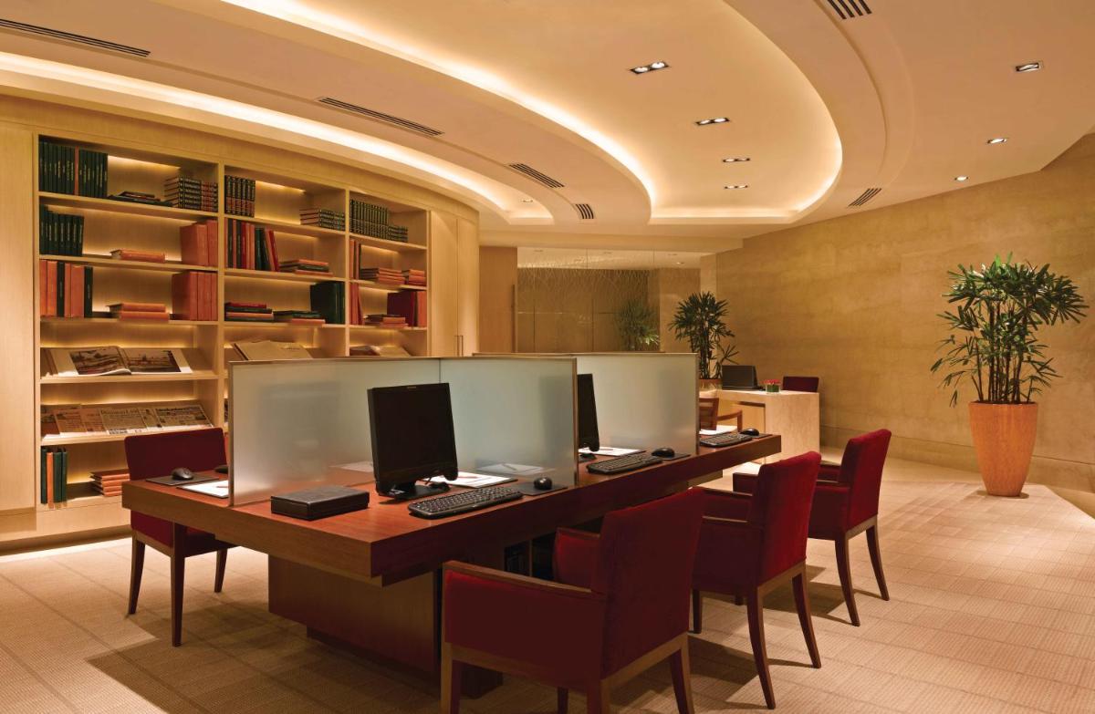an office with a long desk with chairs and a computer at Trident Bandra Kurla in Mumbai an office with a long desk with chairs and a computer at Trident Bandra Kurla in Mumbai