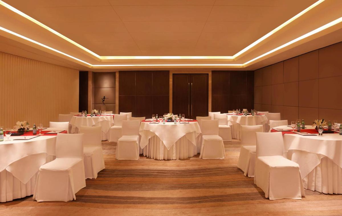 a banquet hall with white tables and white chairs at Trident Bandra Kurla in Mumbai a banquet hall with white tables and white chairs at Trident Bandra Kurla in Mumbai