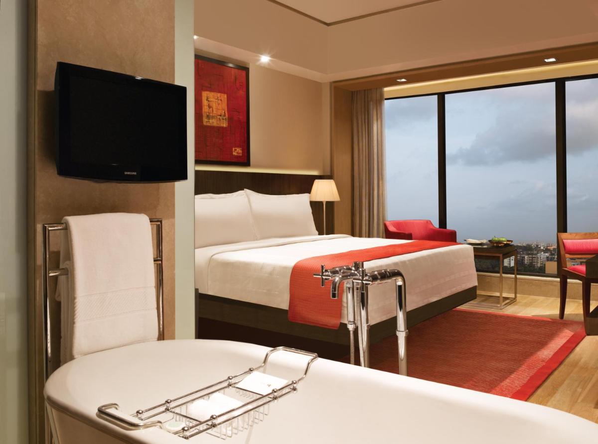 a hotel room with a bed and a bath tub at Trident Bandra Kurla in Mumbai a hotel room with a bed and a bath tub at Trident Bandra Kurla in Mumbai
