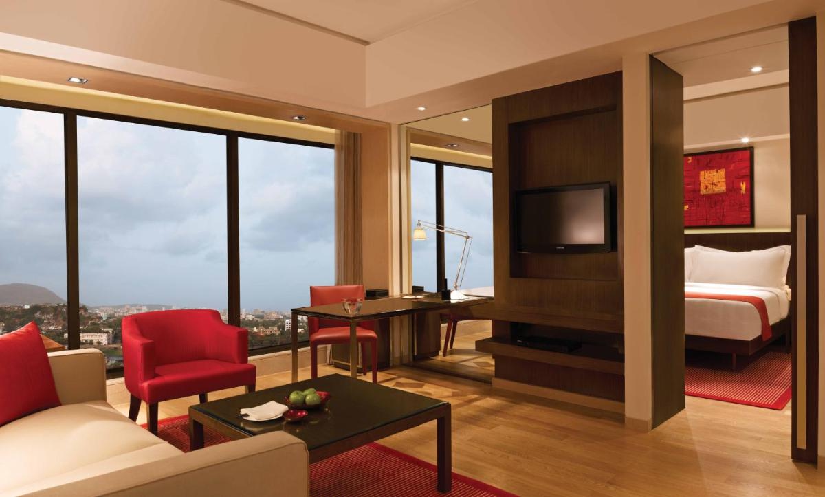 a room with a bed and a living room with a television at Trident Bandra Kurla in Mumbai a room with a bed and a living room with a television at Trident Bandra Kurla in Mumbai