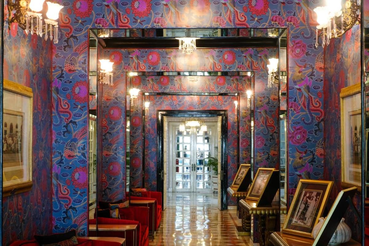 a hallway in a building with blue and red wallpaper at Rajmahal Palace RAAS in Jaipur