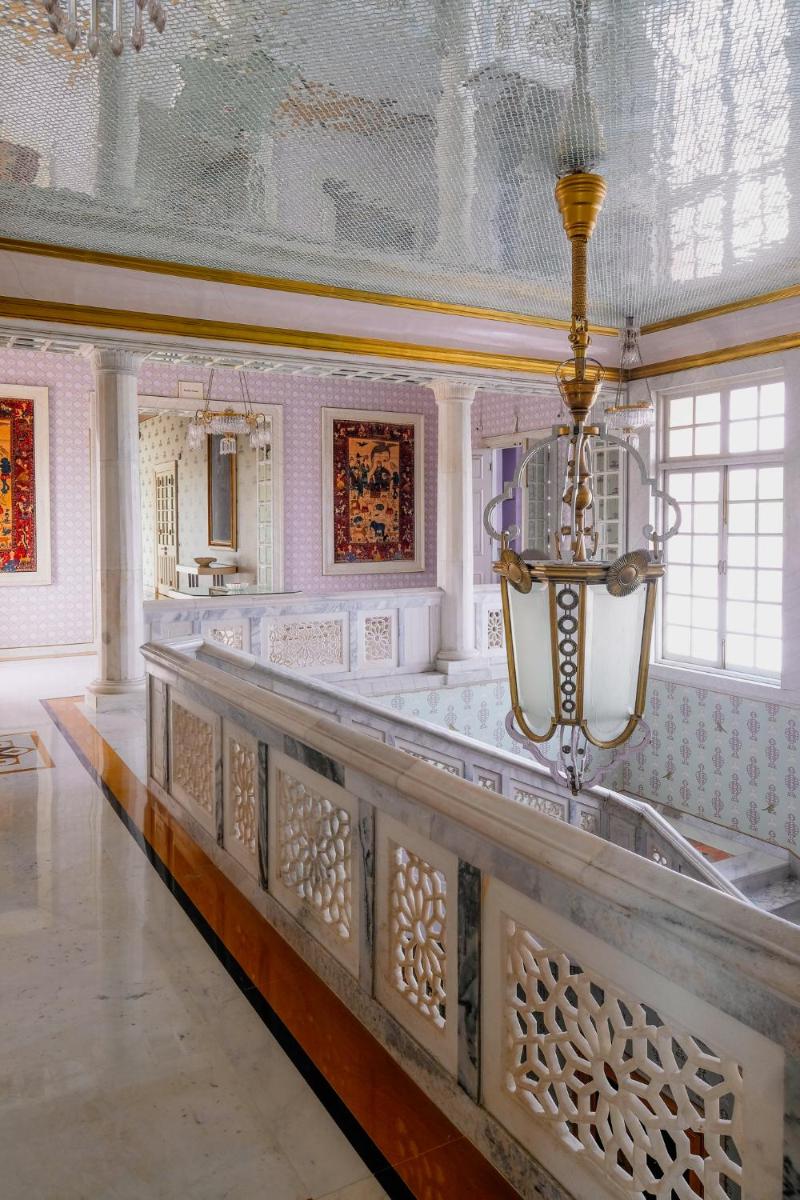 a large room with a table and a chandelier at Rajmahal Palace RAAS in Jaipur