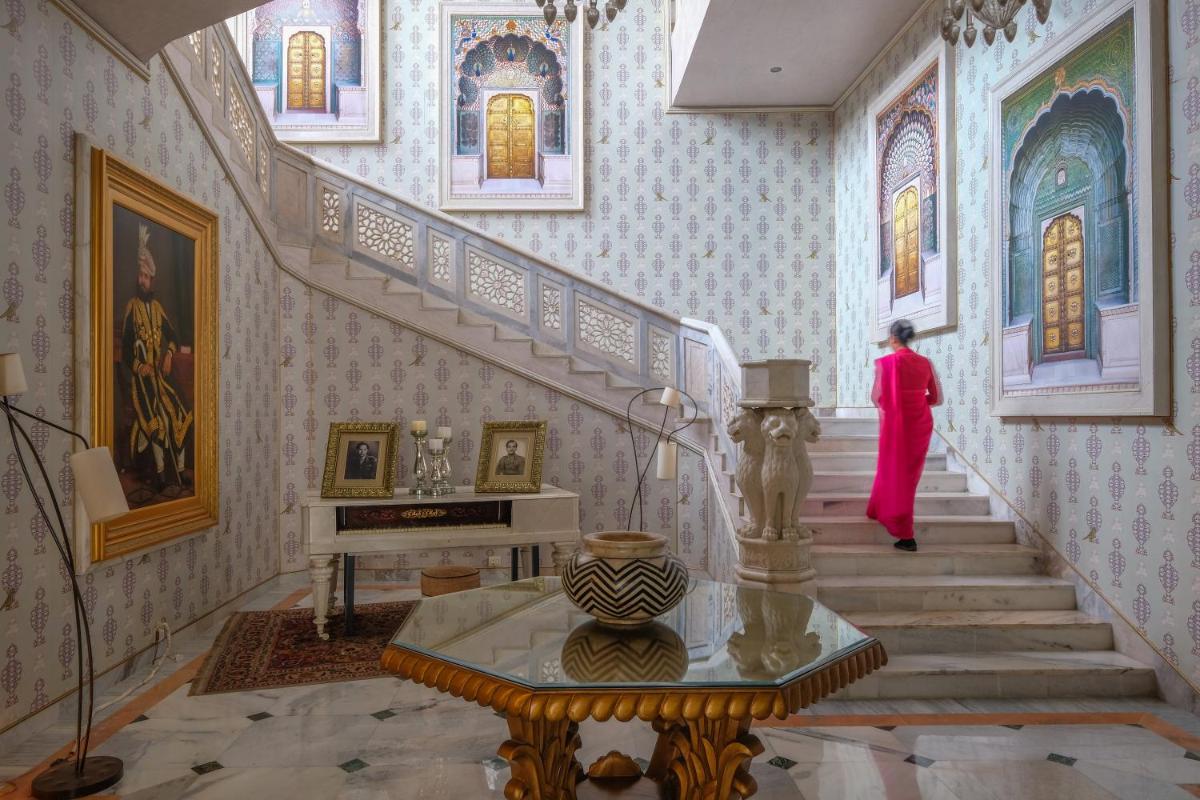a woman walking down a staircase in a room at Rajmahal Palace RAAS in Jaipur