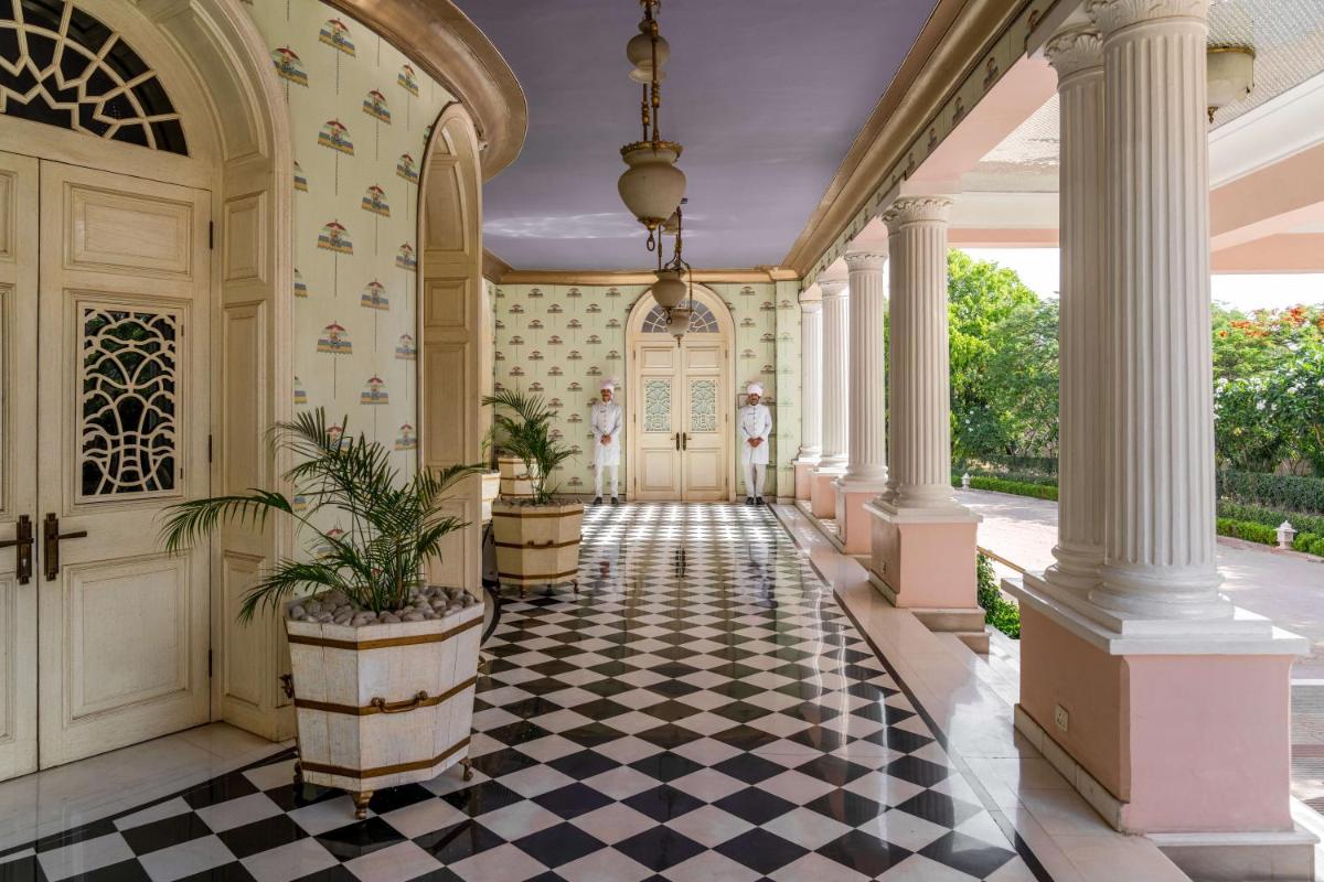 an ornate hallway with a black and white checkered floor at Rajmahal Palace RAAS in Jaipur