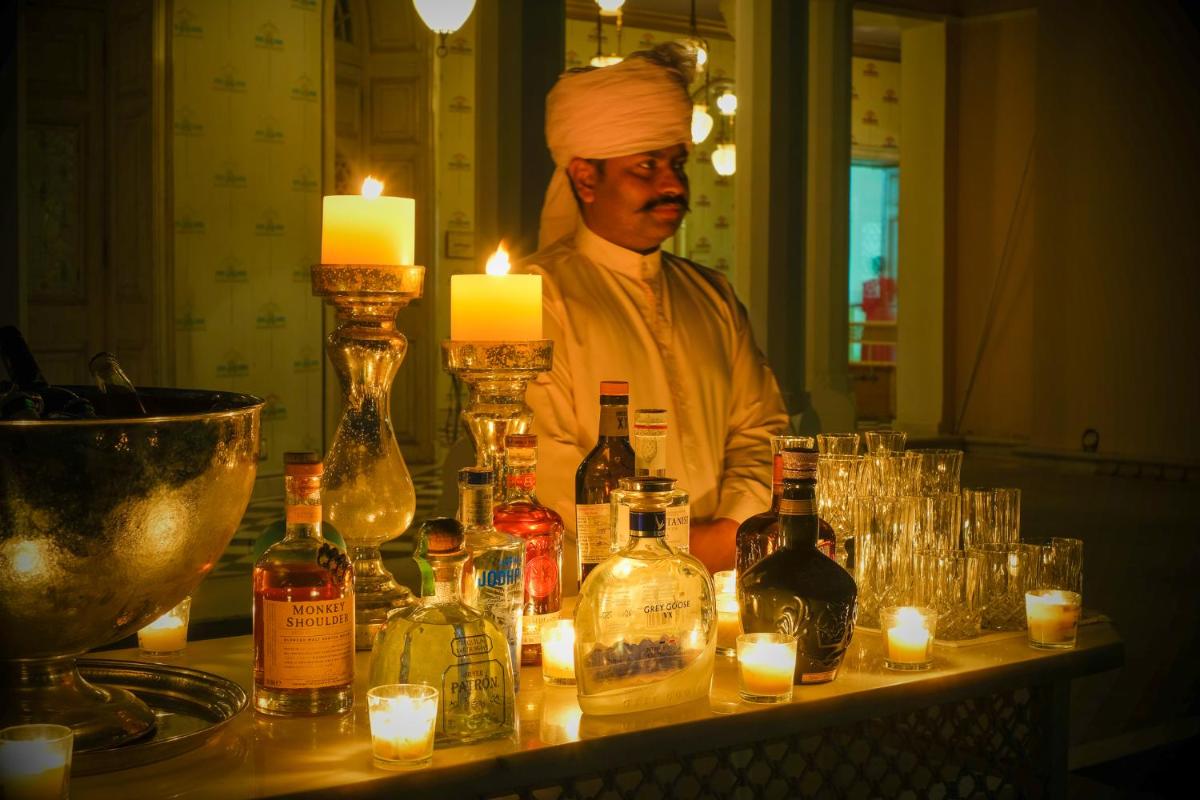 a man standing behind a bar with bottles of alcohol at Rajmahal Palace RAAS in Jaipur