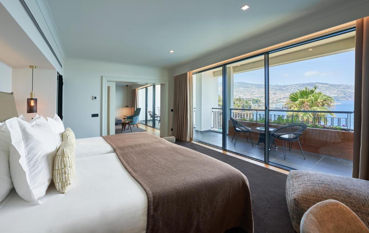 um quarto com uma cama grande e uma janela grande em The Cliff Bay - PortoBay no Funchal