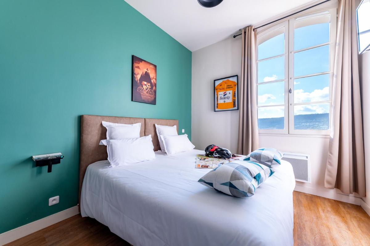 une chambre avec un grand lit et des murs bleus dans l'établissement Le Nesk Ventoux - Hotel, à Sault 40 autres photos