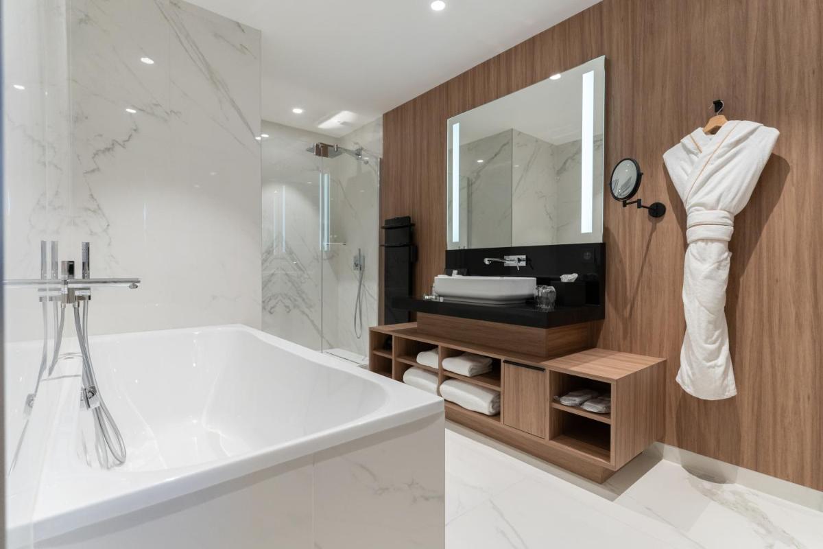 une salle de bain blanche avec une baignoire et un miroir dans l'établissement Les Trésorières, à Tours