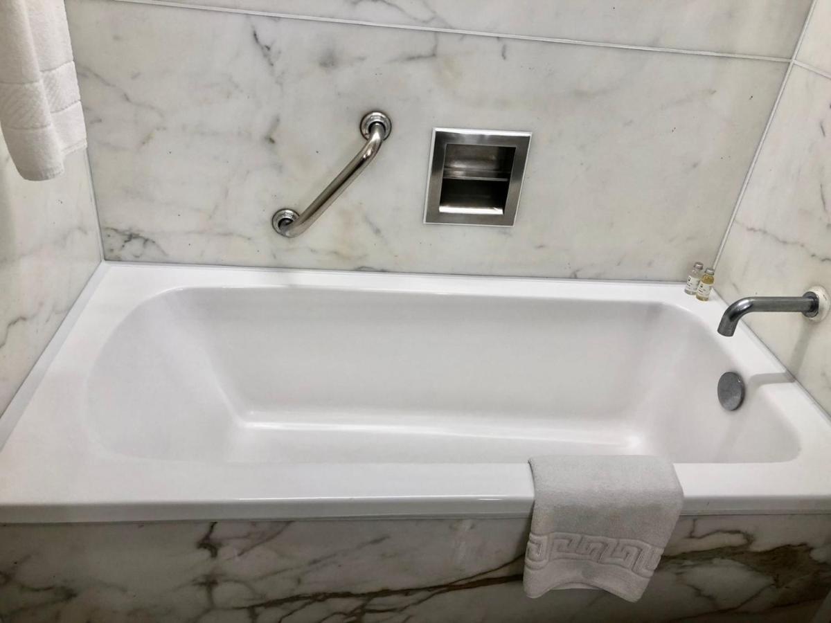 a white bath tub in a bathroom with a towel at Hotel Marine Plaza in Mumbai