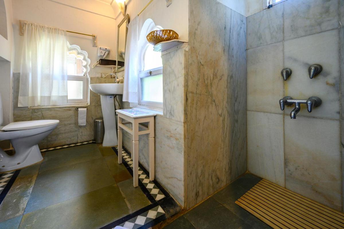 a bathroom with a shower and a sink and a toilet at Neemrana Fort-Palace in Neemrana