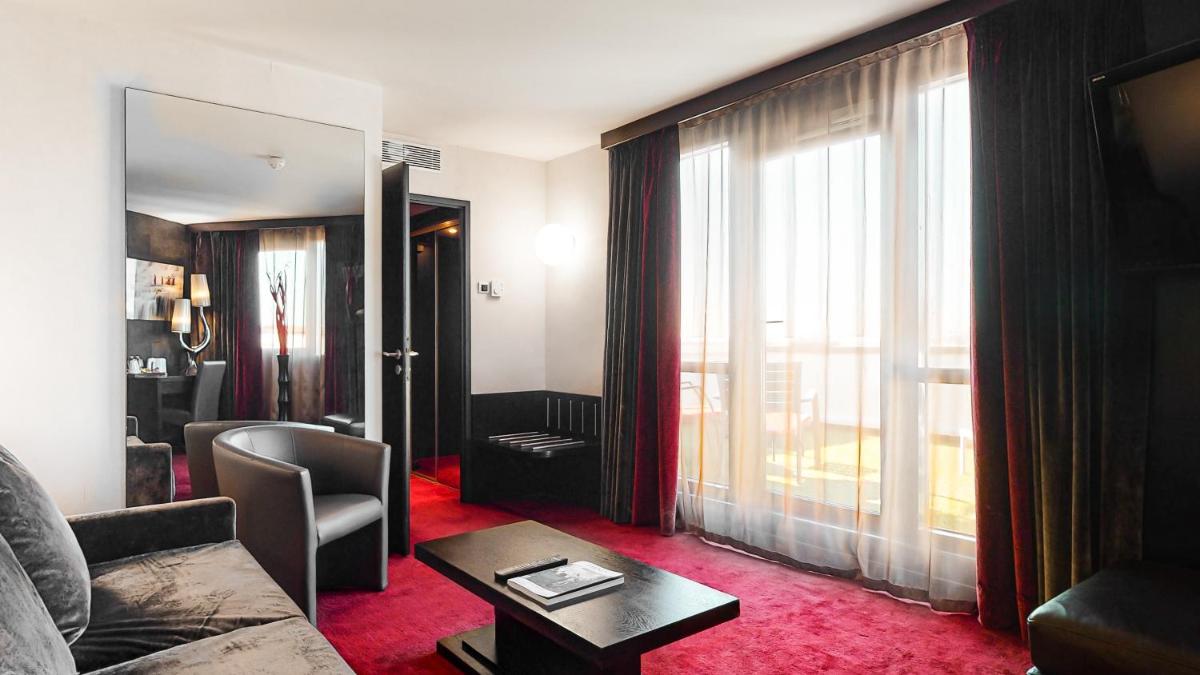 un salon avec un canapé et une table dans l'établissement Hotel Palladia, à Toulouse