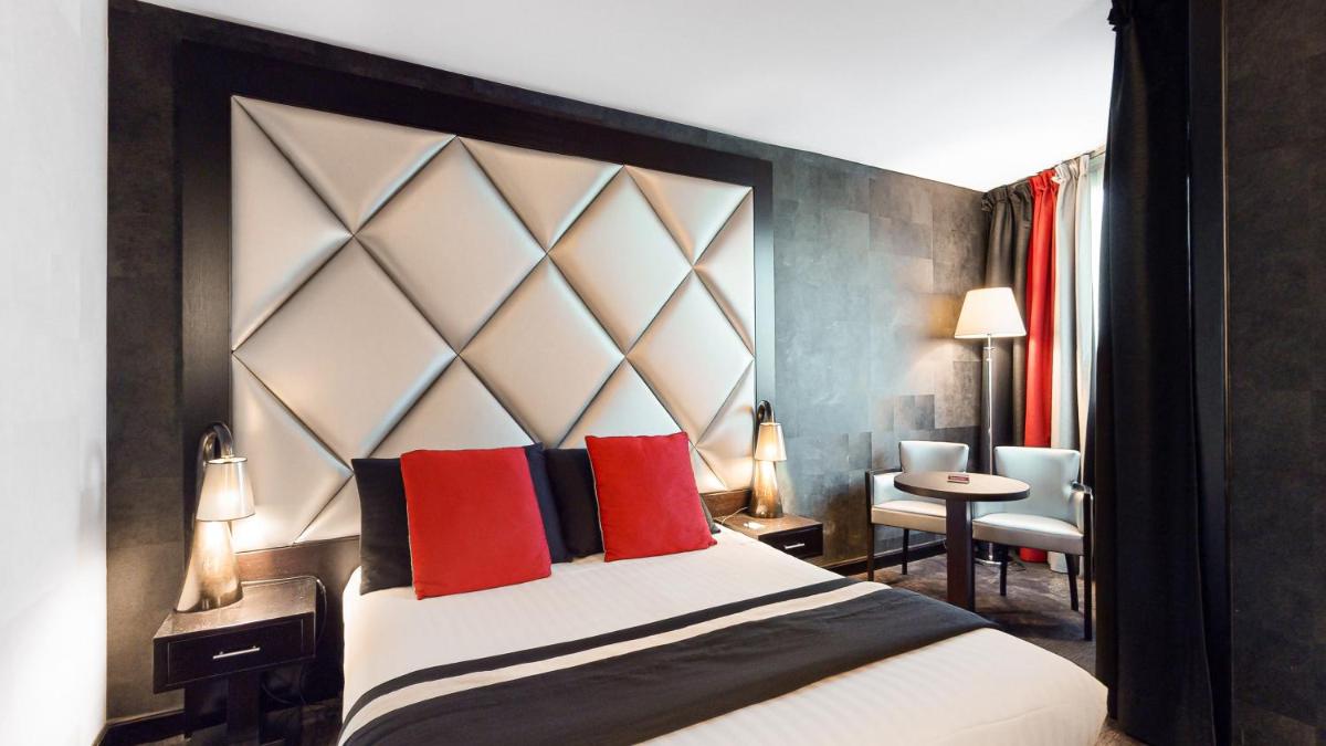 une chambre avec un grand lit aux oreillers rouges dans l'établissement Hotel Palladia, à Toulouse