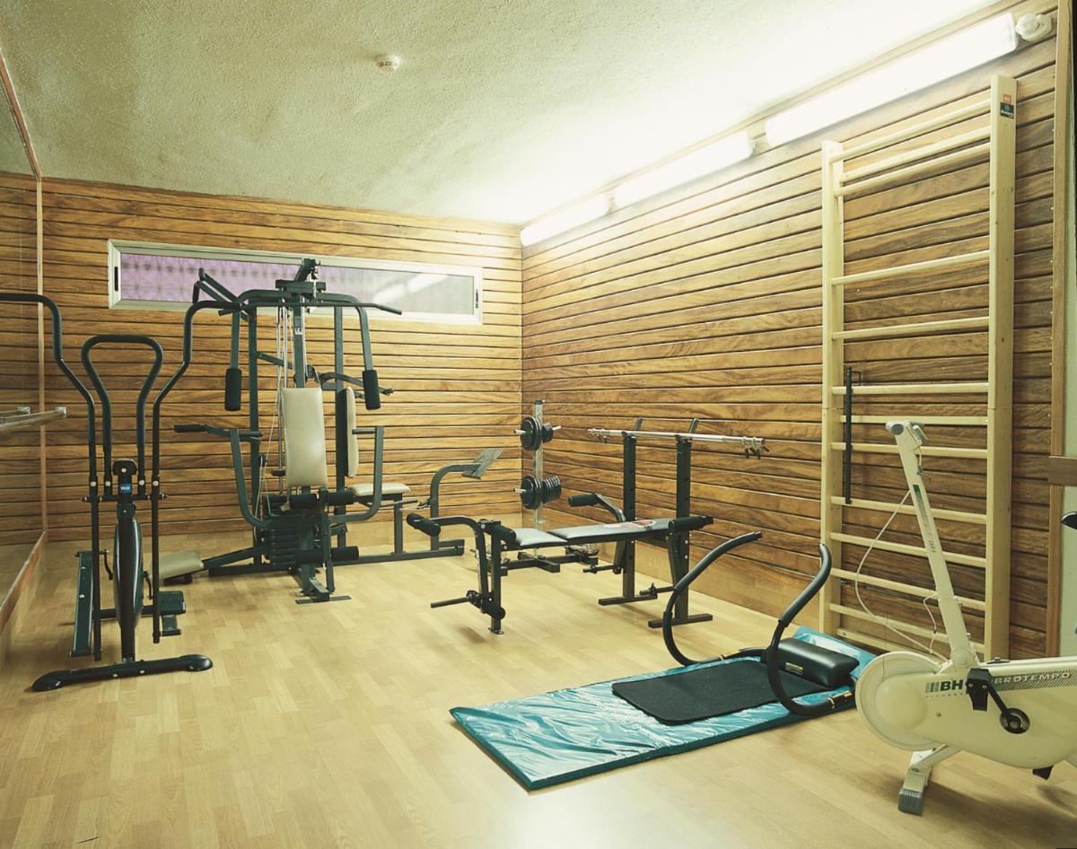 un gimnasio con equipamiento de ejercicio en una habitación en Fenals Garden, en Lloret de Mar