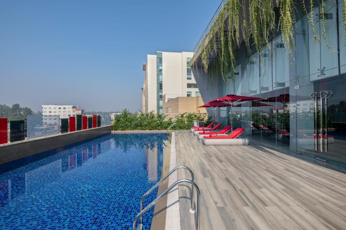 a swimming pool on the roof of a building at Radisson RED Chandigarh Mohali in Chandīgarh