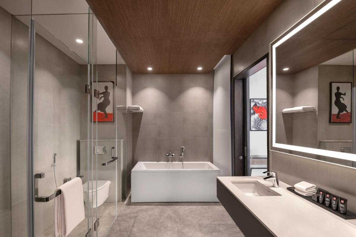 a bathroom with a bath tub and a sink at Radisson RED Chandigarh Mohali in Chandīgarh