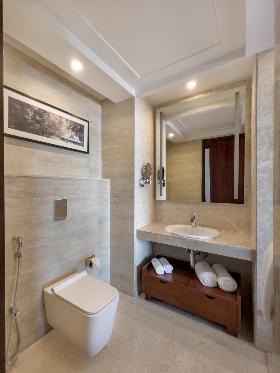 a bathroom with a sink and a toilet and a mirror at Radisson Kufri in Shimla +77 photos