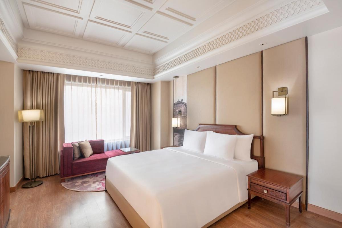 a bedroom with a large white bed and a couch at Radisson Kufri in Shimla