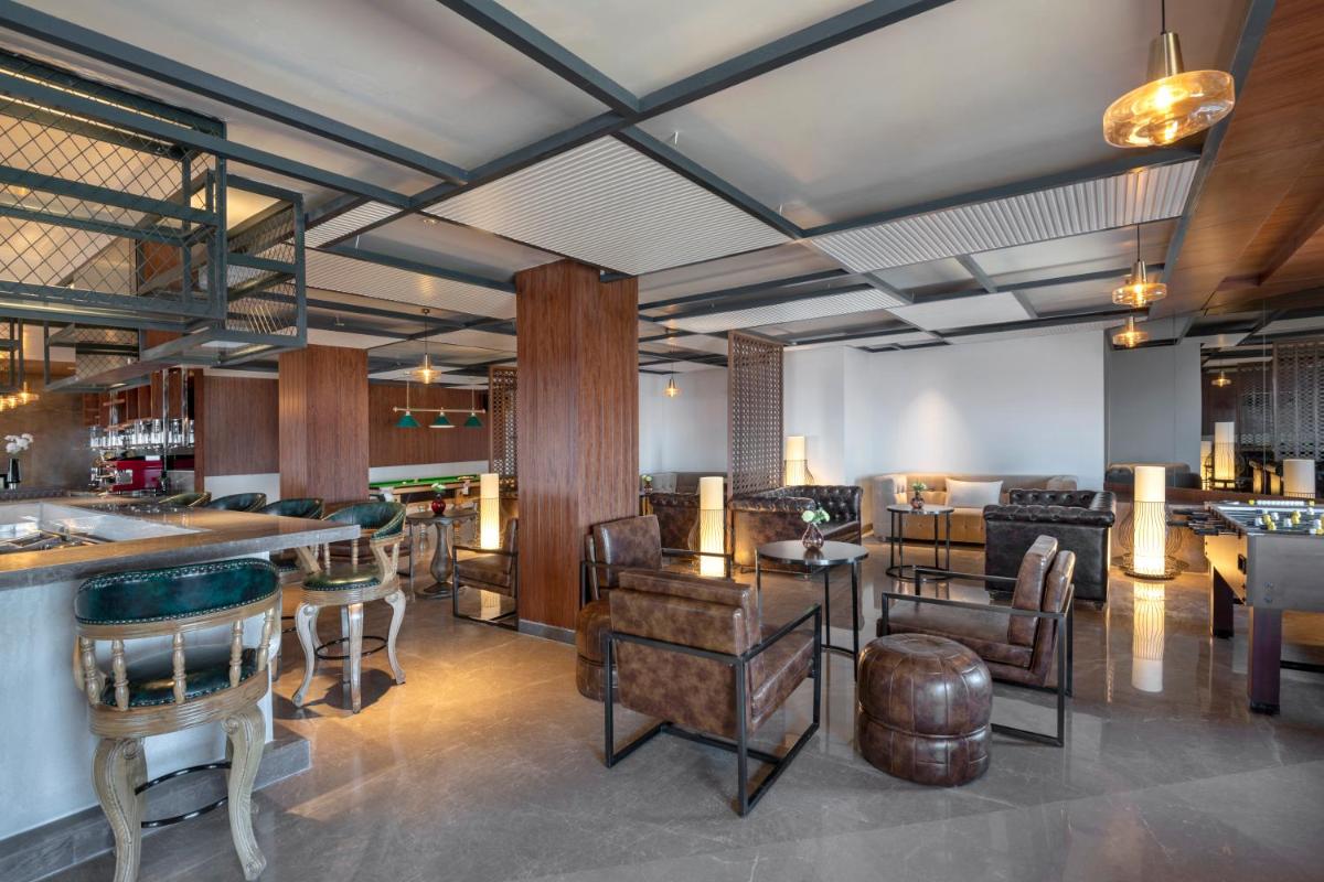 a lobby with a bar and some tables and chairs at Radisson Kufri in Shimla
