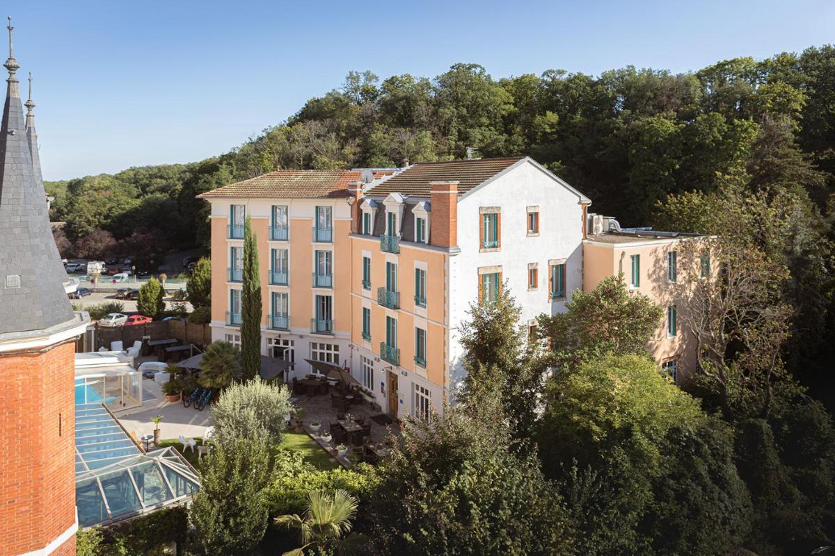 un bâtiment avec une montagne en arrière-plan dans l'établissement Hôtel Spa Thermalia, à Châtel-Guyon