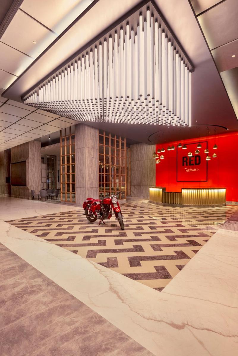 a red motorcycle parked in a lobby with a building at Radisson RED Chandigarh Mohali in Chandīgarh