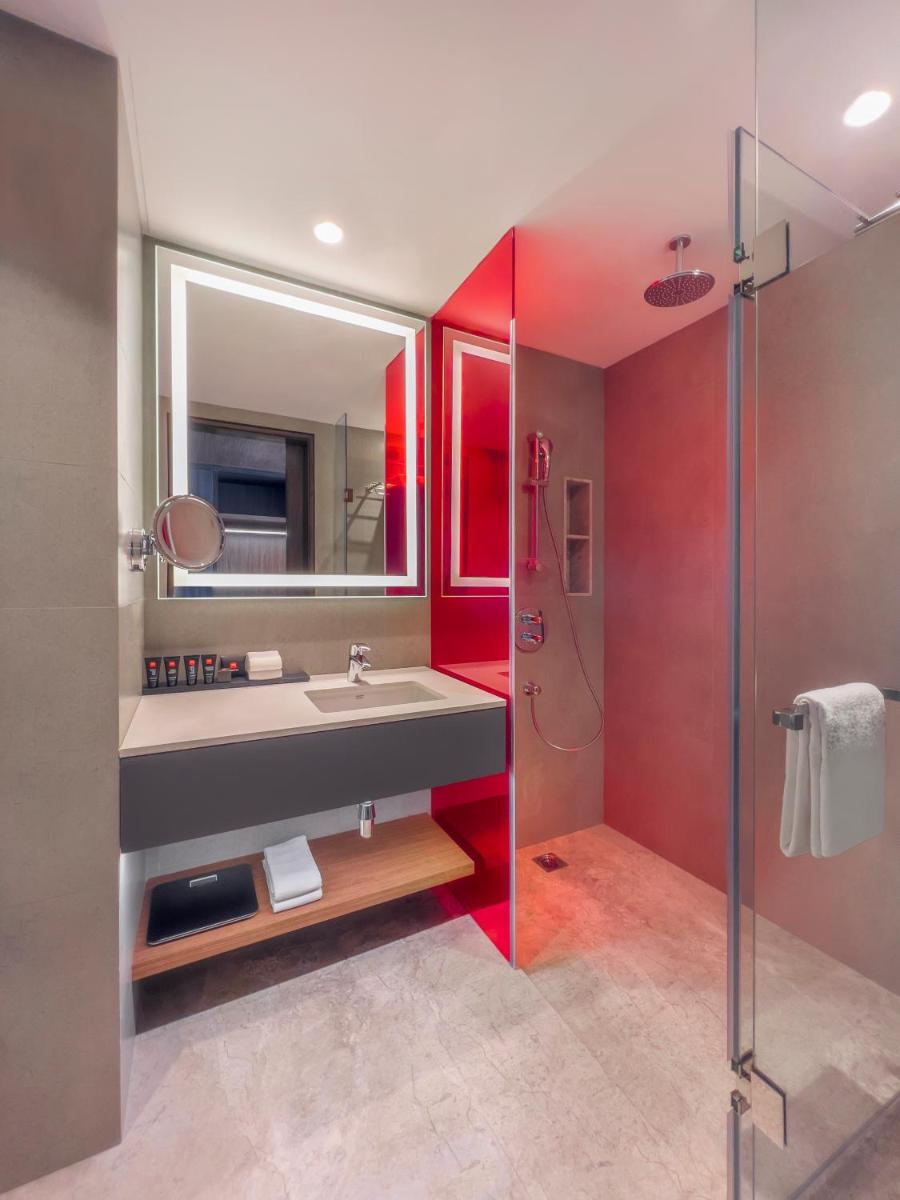 a bathroom with a sink and a shower at Radisson RED Chandigarh Mohali in Chandīgarh